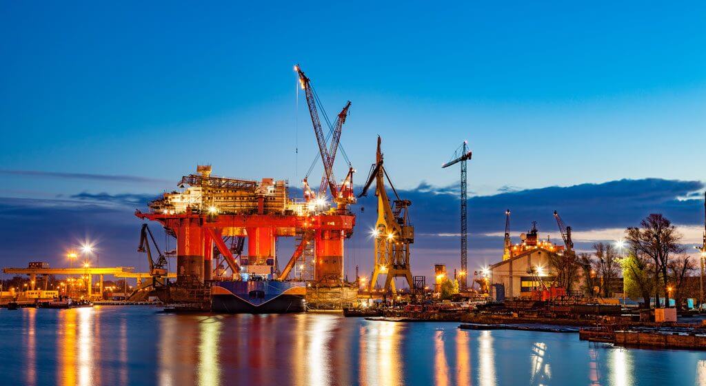 Evening view of cargo dock. Water reflects working lights.